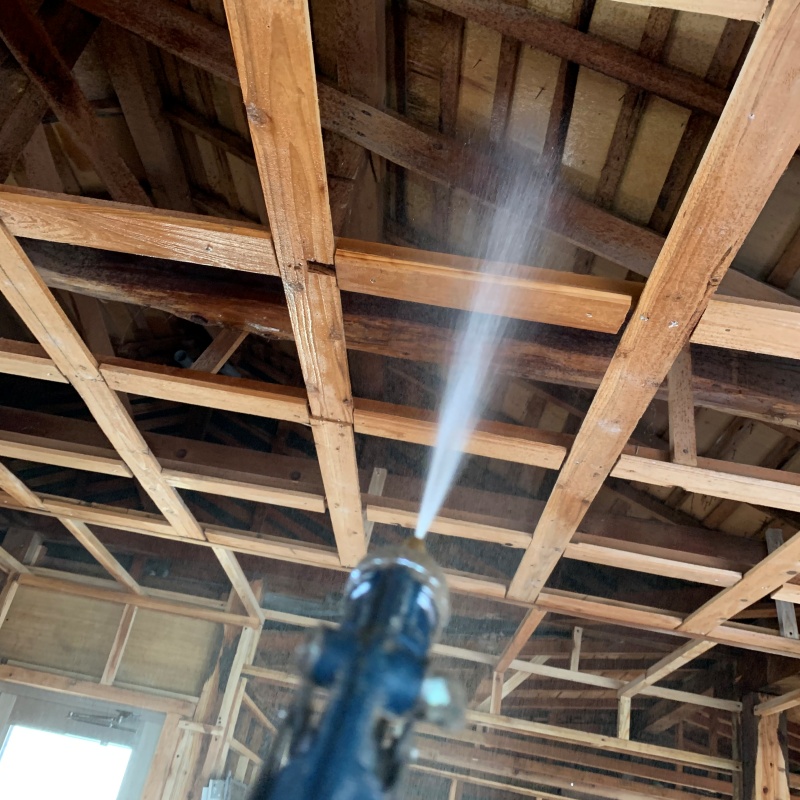 屋根裏の木材にシロアリ駆除剤を散布