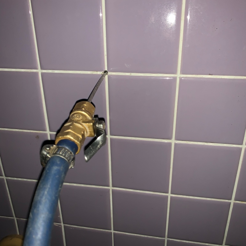 トイレ壁に穴を開けてシロアリ駆除剤を注入