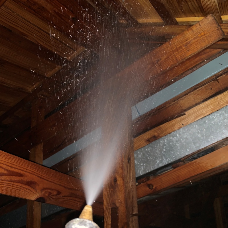 屋根裏の木材にシロアリ駆除剤を散布