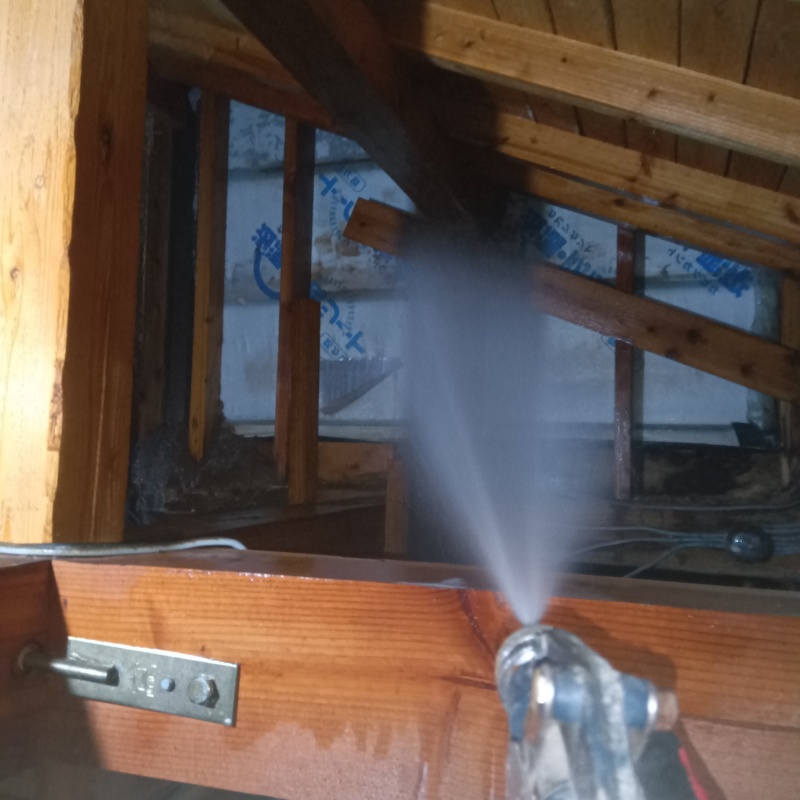 屋根裏の木材にシロアリ駆除剤を散布