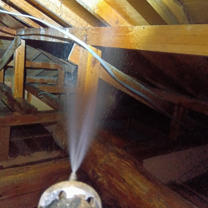 屋根裏の木材にシロアリ駆除剤を散布