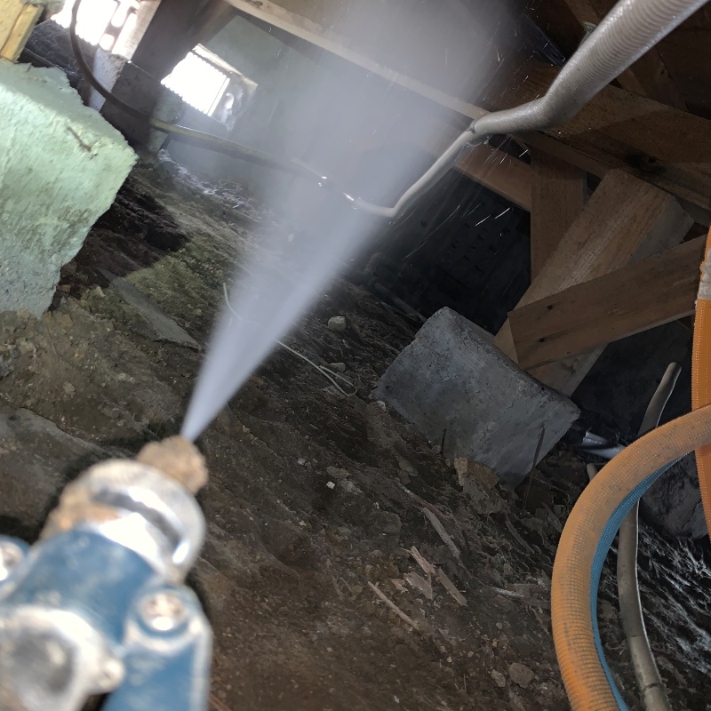 床下木材にシロアリ駆除剤を吹き付けている様子