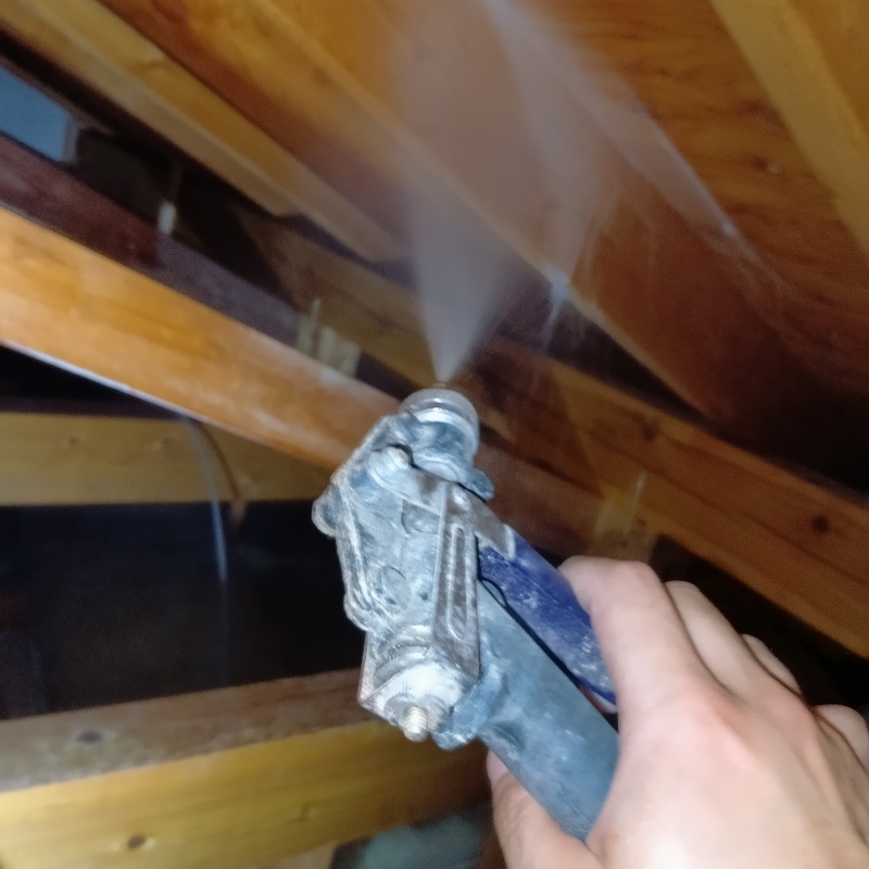 屋根裏の木材にシロアリ駆除剤を散布