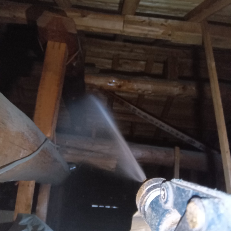 屋根裏の木材にシロアリ駆除剤を散布