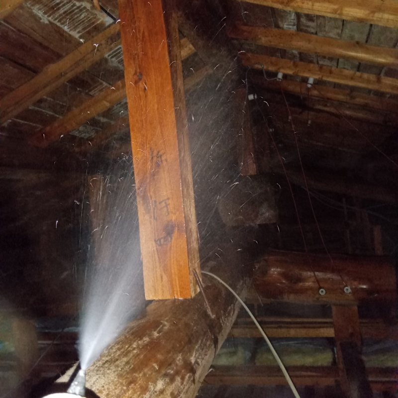 屋根裏の木材にシロアリ駆除剤を散布