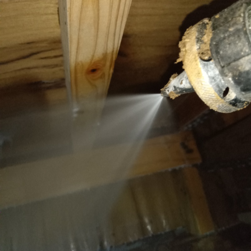 床下木材にシロアリ駆除剤を吹き付けている様子