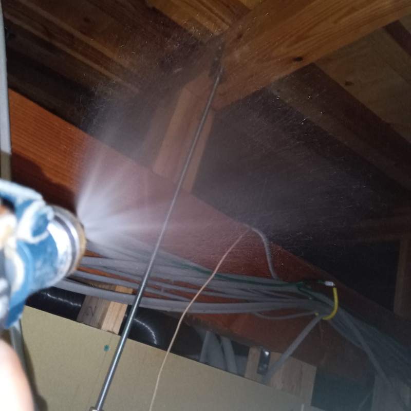 屋根裏の木材にシロアリ駆除剤を散布