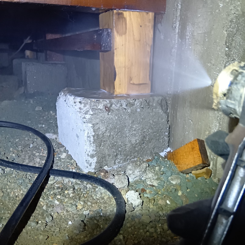 床下木材にシロアリ駆除剤を吹き付けている様子