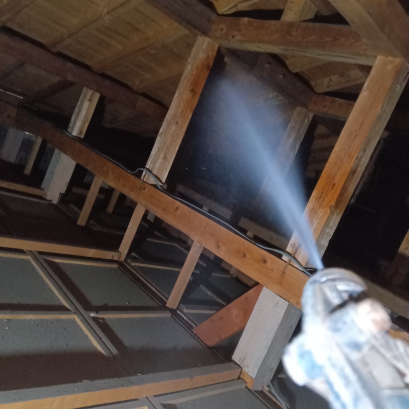 屋根裏の木材にシロアリ駆除剤を散布