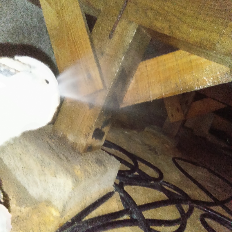 床下木材に防蟻剤を吹き付ける様子