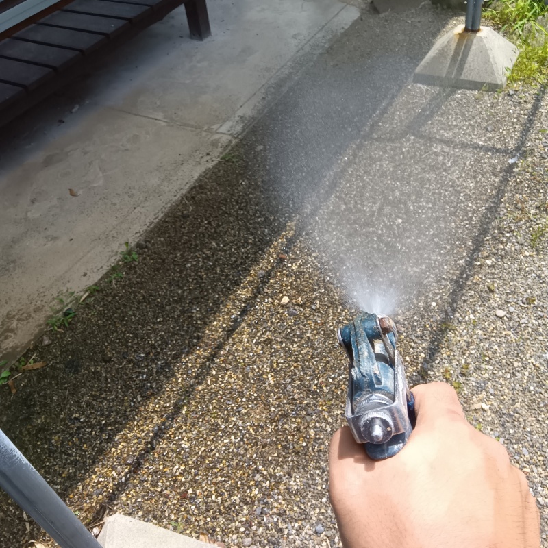 建物外周の土壌にシロアリ駆除剤を吹き付けている様子