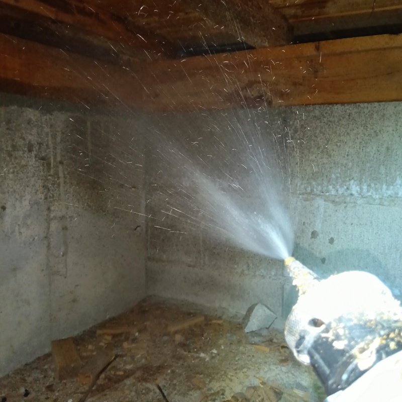基礎にシロアリ駆除剤を吹き付けている様子