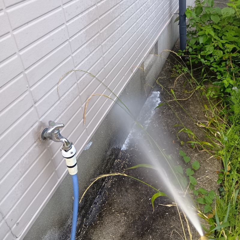 屋外の地面にシロアリ駆除剤を散布