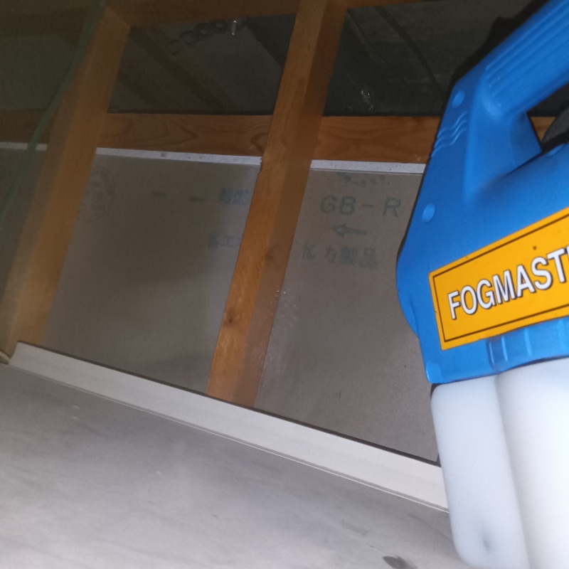 浴室の上から噴霧器でシロアリ駆除剤を散布