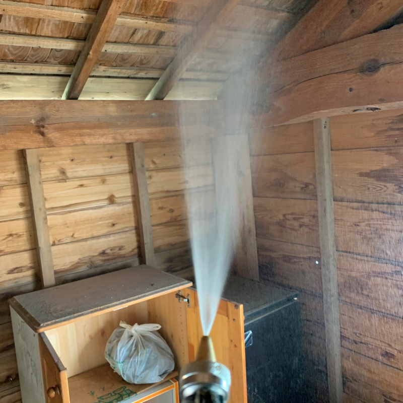 小屋の屋根にシロアリ駆除剤を散布