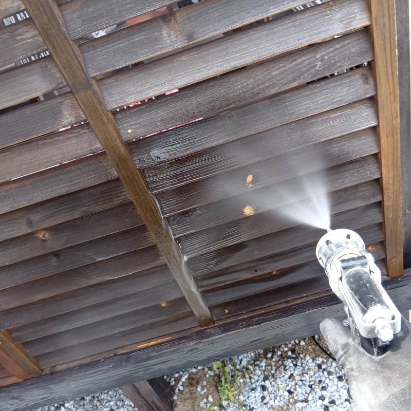 木塀にシロアリ駆除剤を吹き付ける様子