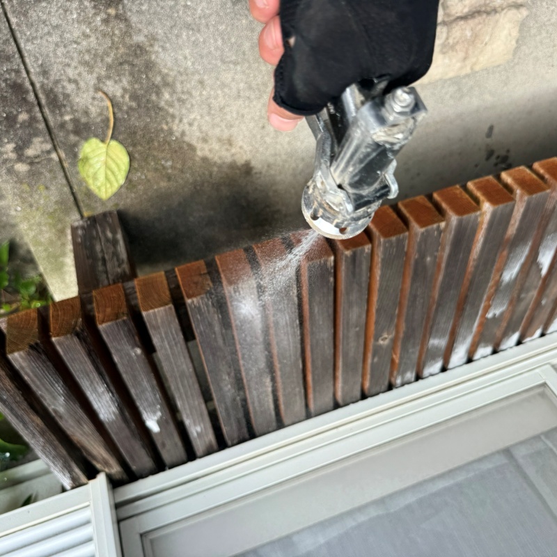 木塀にシロアリ駆除剤を吹き付ける様子