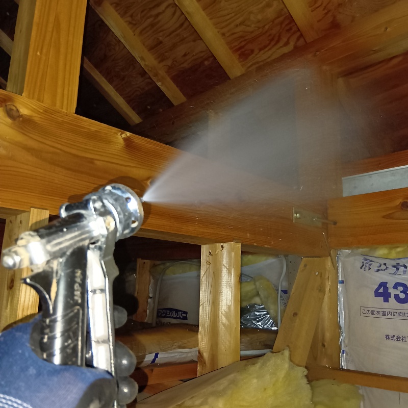 屋根裏の木材にシロアリ駆除剤を散布