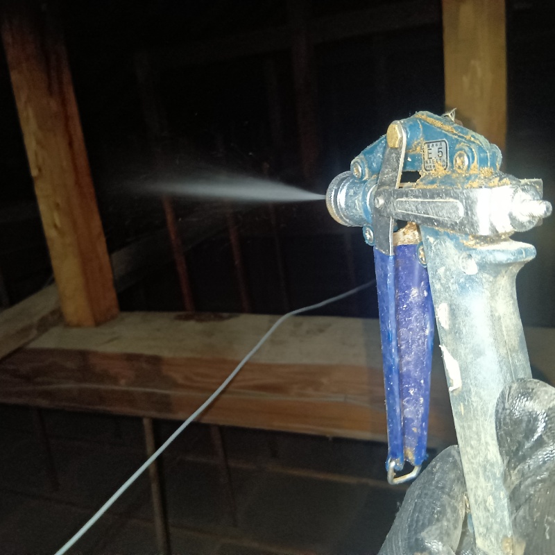 屋根裏の木材にシロアリ駆除剤を散布