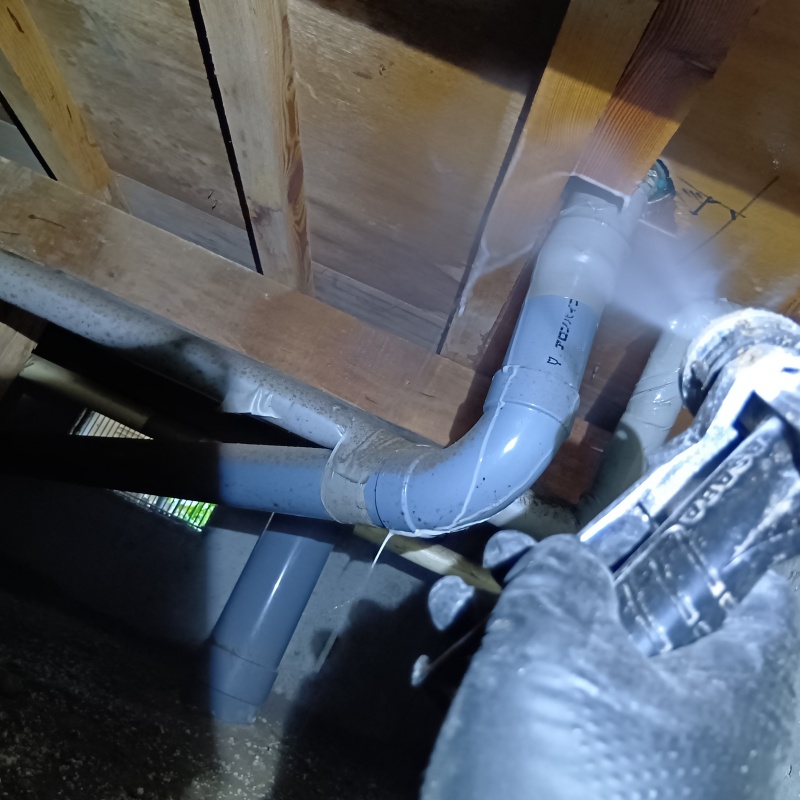 床下木材にシロアリ駆除剤を吹き付けている様子