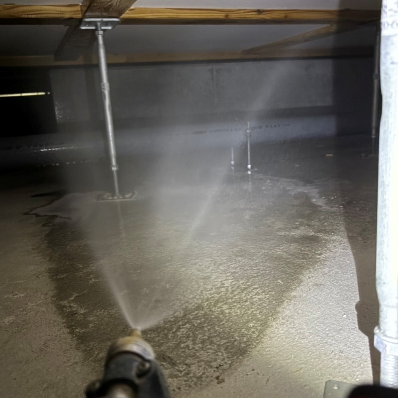 地面にシロアリ駆除剤を吹き付けている様子