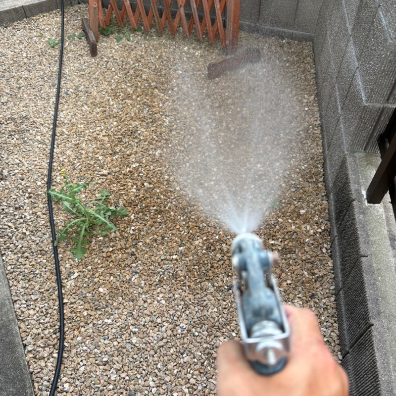 建物外周の土壌にシロアリ駆除剤を吹き付けている様子