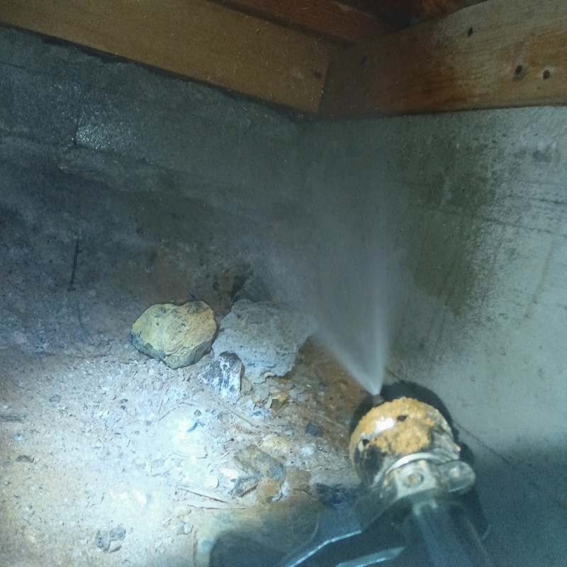 基礎にシロアリ駆除剤を吹き付けている様子