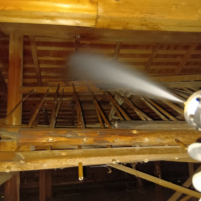 屋根裏の木材にシロアリ駆除剤を散布