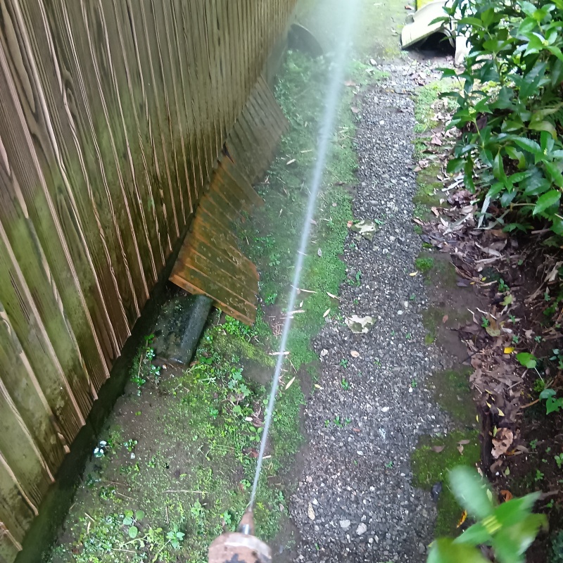 建物外周の土壌にシロアリ駆除剤を吹き付ける様子