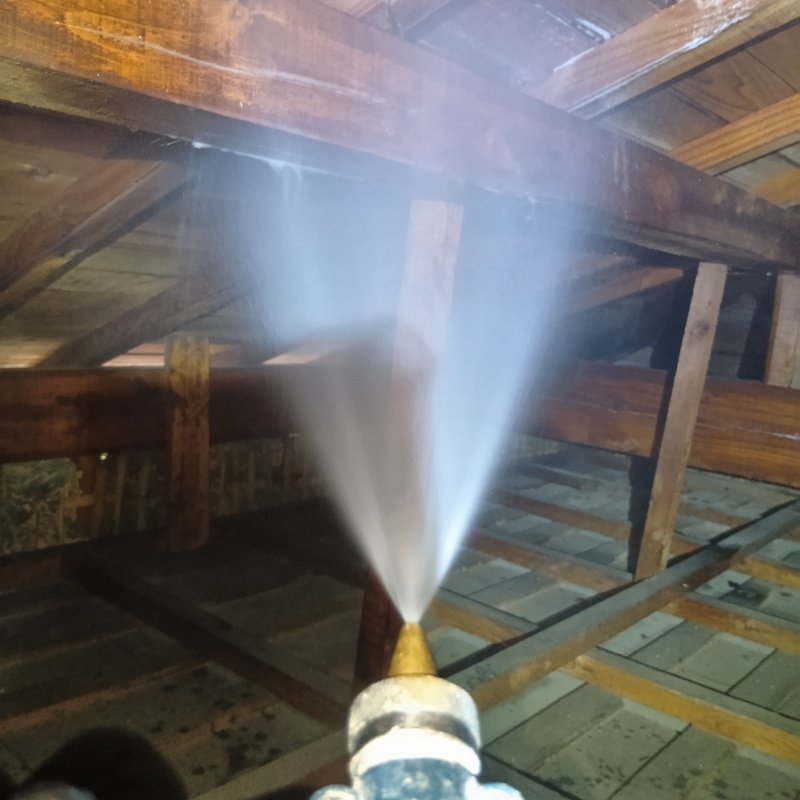 屋根裏の木材にシロアリ駆除剤を散布