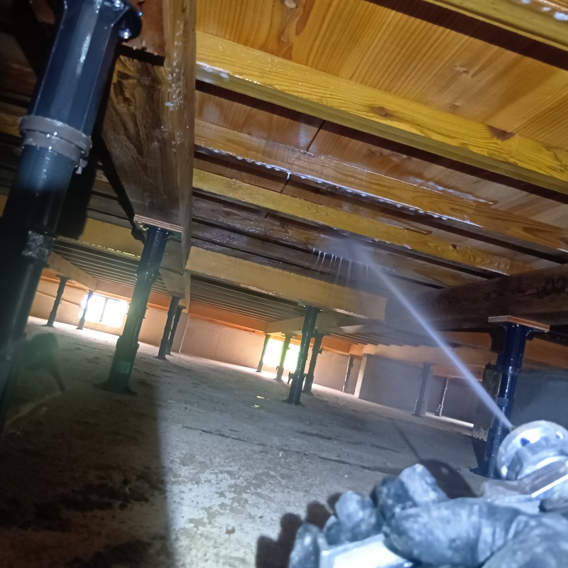 床下木材にシロアリ駆除剤を吹き付けている様子