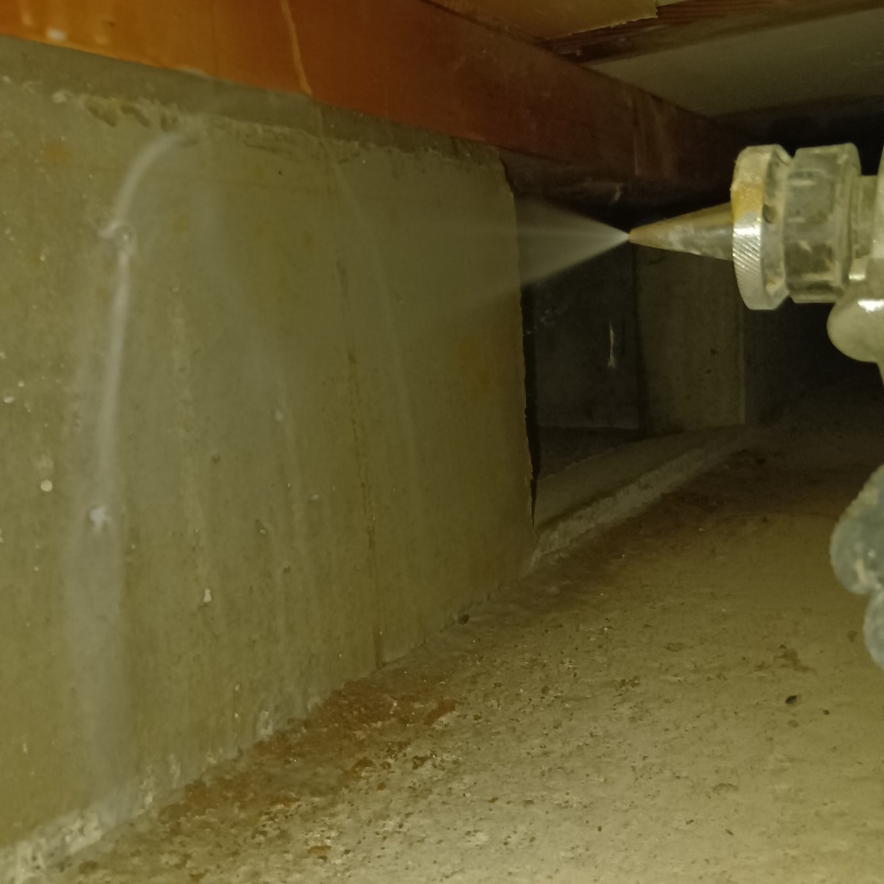 基礎にシロアリ駆除剤を吹き付けている様子