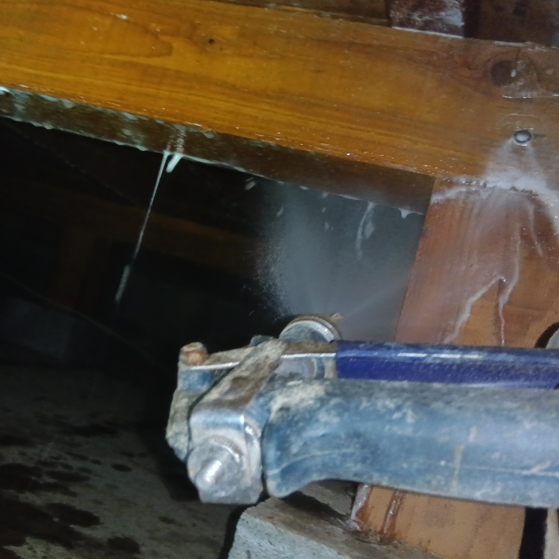 床下木材にシロアリ駆除剤を吹き付けている様子