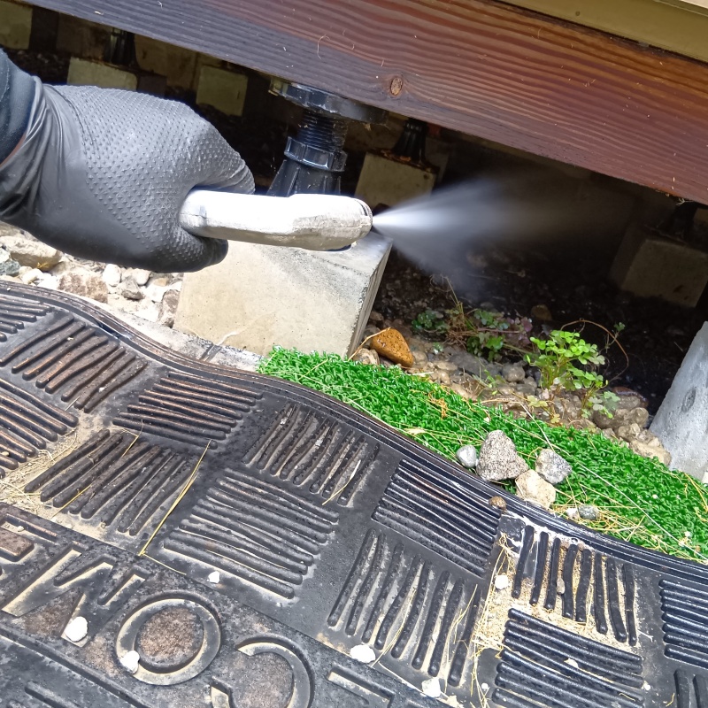 建物の下（開口部）からシロアリ駆除剤を散布
