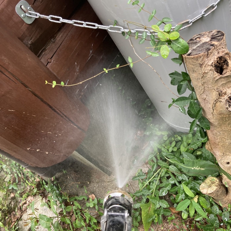 ボンベとフェンスのすき間に防蟻剤を散布