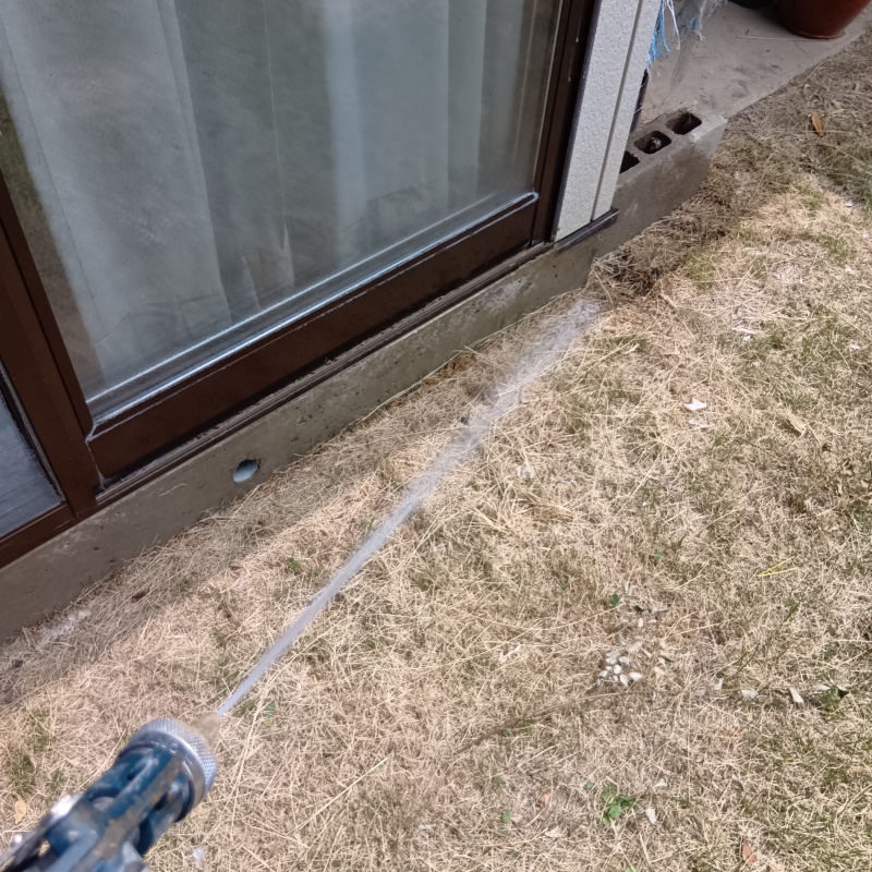 庭先にシロアリ駆除剤を散布