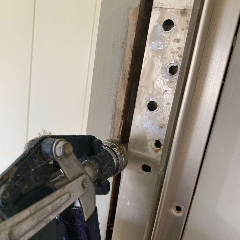 玄関壁のすき間にシロアリ駆除剤を注入