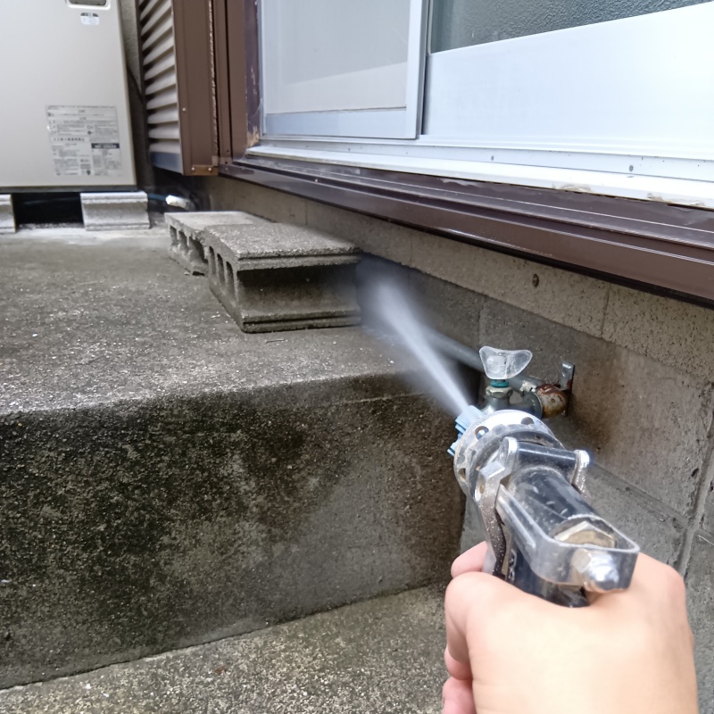 屋外の地面にシロアリ駆除剤を散布