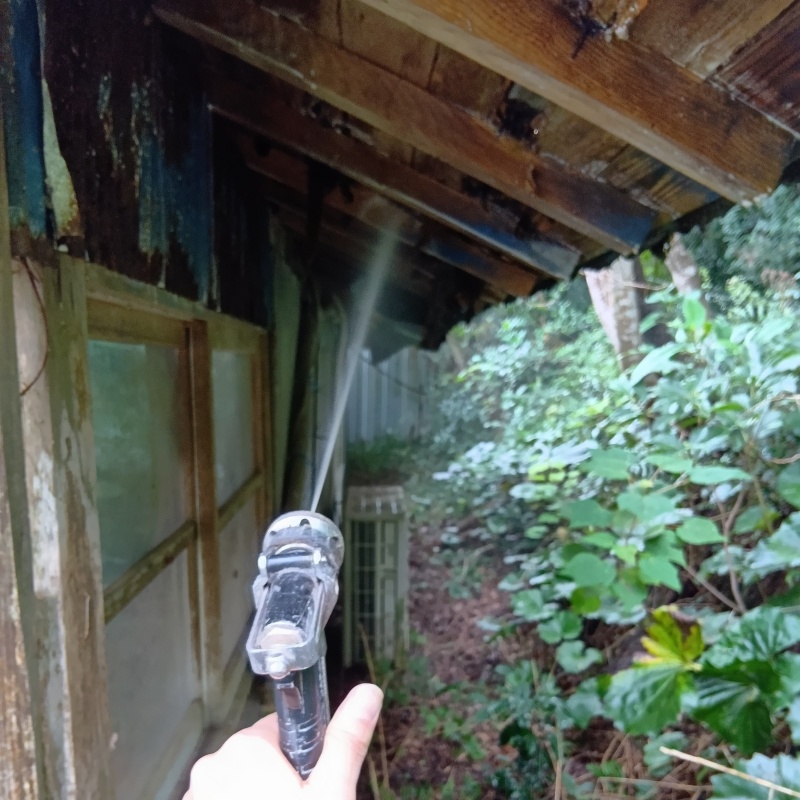 屋外の木製屋根にシロアリ駆除剤を散布