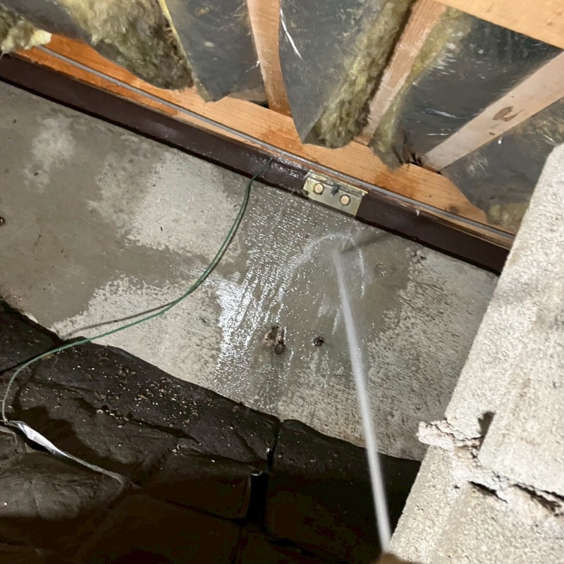 基礎にシロアリ駆除剤を吹き付けている様子