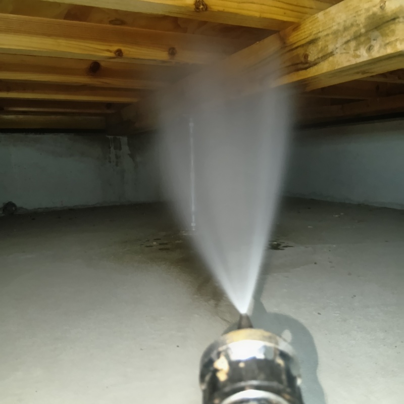 床下木材に防蟻剤を吹き付ける様子