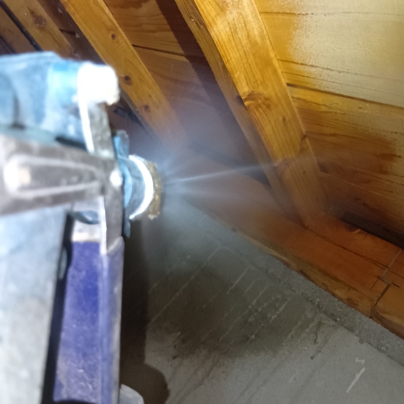 床下木材にシロアリ駆除剤を吹き付ける様子