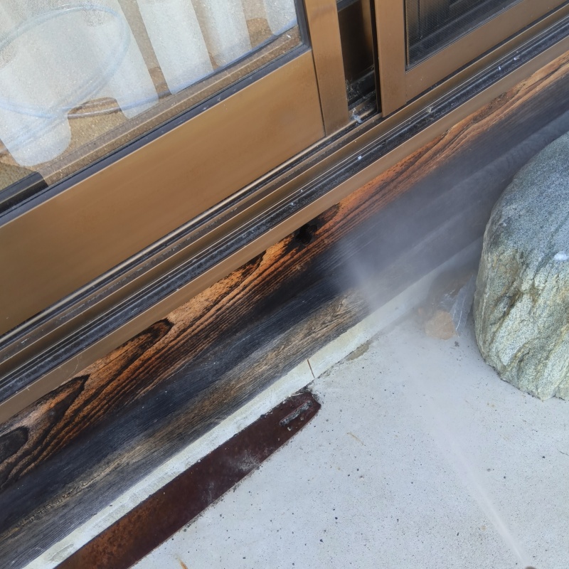 窓枠の木部にシロアリ駆除剤を散布