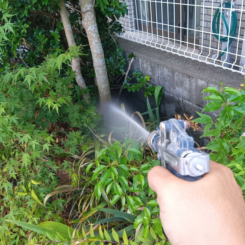 屋外の地面にシロアリ駆除剤を散布