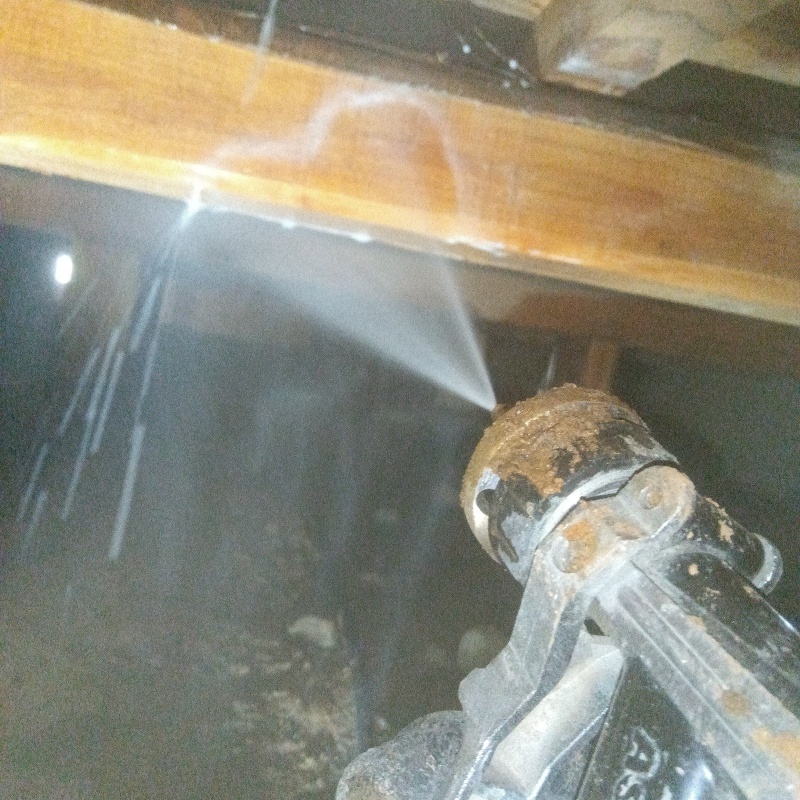 床下の木材に防蟻剤を散布する様子