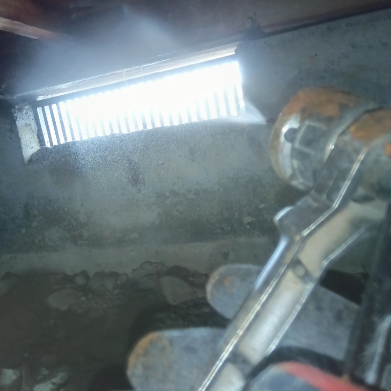 床下の基礎部分に防蟻剤を散布する様子