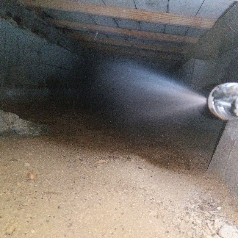 床下の土壌にシロアリ駆除を散布する様子