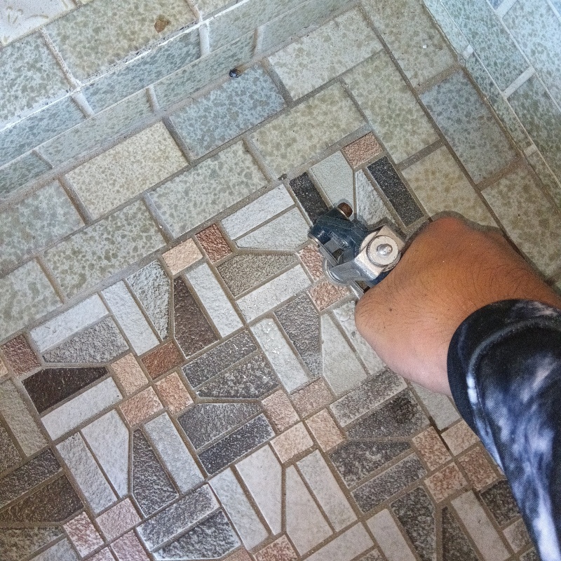 玄関の床にシロアリ駆除を注入する様子