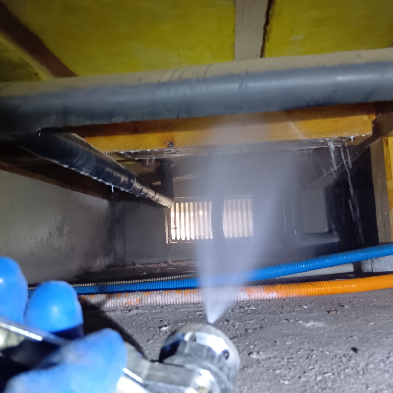 床下の木材にシロアリ駆除を散布する様子