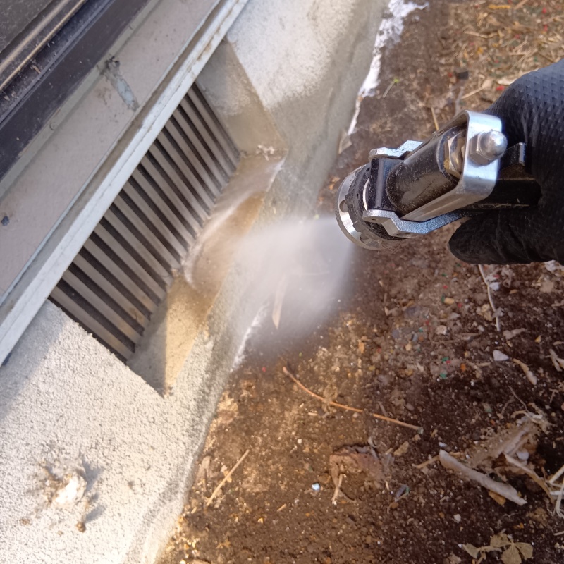 基礎まわりにシロアリ駆除を散布する様子